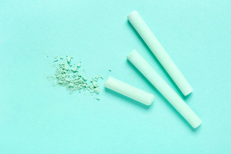 Green chalks with crushed pigment on turquoise backgroundの写真素材