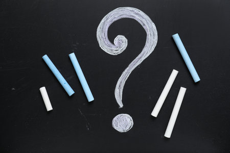 Colorful chalks and drawn question mark on blackboardの写真素材
