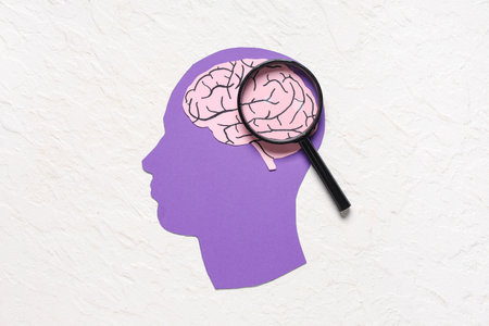 Paper human head with brain and magnifying glass on white background. Cancer conceptの写真素材