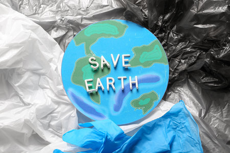 Paper planet with text SAVE EARTH on plastic bagsの写真素材