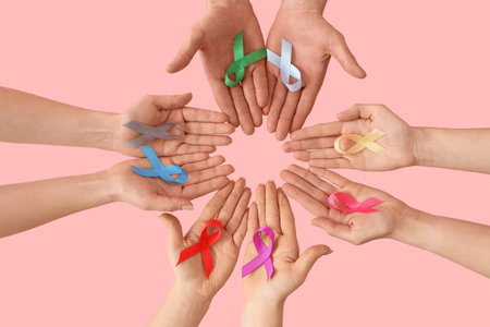 Many hands with different ribbons on pink background, top view. Cancer awareness conceptの写真素材
