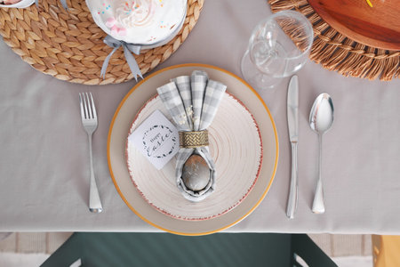 Festive table setting with egg in napkin on plate. Top view