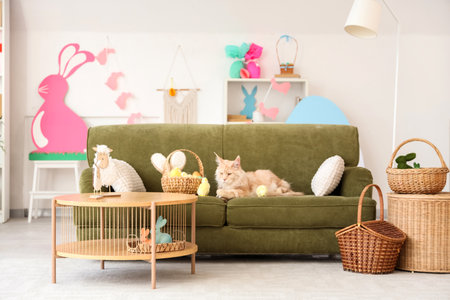 Cute cat with Easter basket and chicks lying on sofa in living roomの写真素材