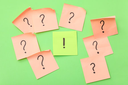 Sticky notes with question and exclamation marks on green backgroundの写真素材