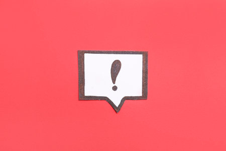 Paper speech bubble with exclamation mark on red backgroundの写真素材