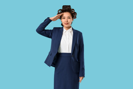 Young Asian stewardess with hair curlers on blue backgroundの写真素材