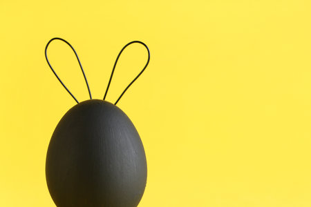 Creative Easter egg with bunny ears on yellow background, closeupの写真素材