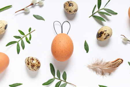 Composition with Easter eggs and plant leaves on light background