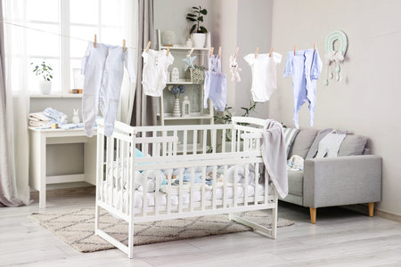 Rope with hanging baby clothes and toys in nursery