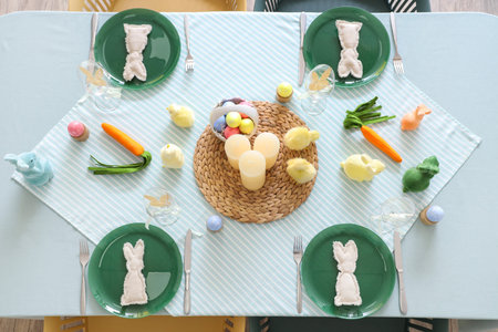 Festive table setting with Easter rabbits, chickens and eggs in kitchen