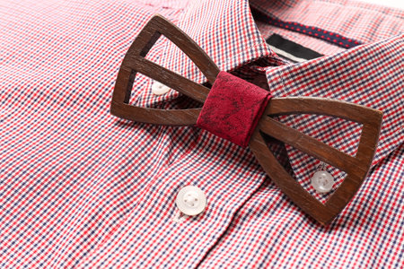 Closeup view of stylish red checkered shirt with wooden bow tieの写真素材