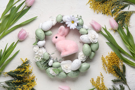 Composition with flowers, Easter eggs and wreath on white grunge background