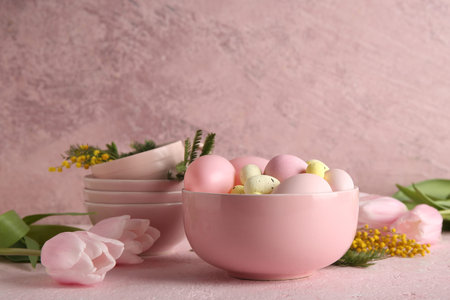 Composition with flowers, Easter eggs and bowl on pink grunge backgroundの写真素材