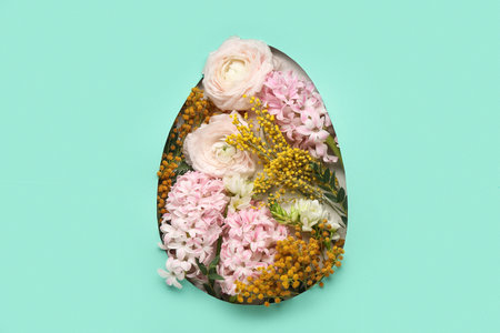 Different flowers visible through hole in shape of egg on turquoise background. Easter celebrationの写真素材