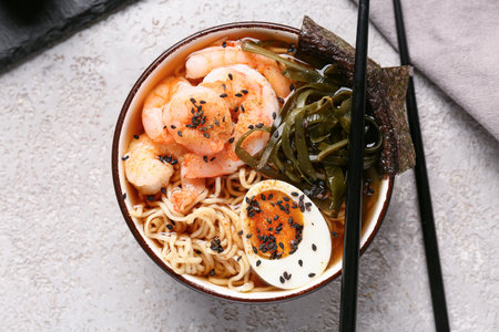 Bowl of ramen noodle soup with shrimps and seaweed sheets on white backgroundの写真素材