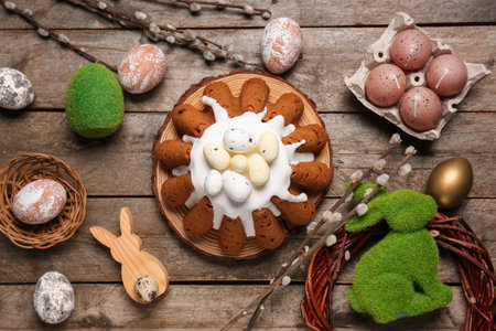 Board of sweet Easter bread with eggs, rabbit and willow branches on wooden backgroundの写真素材
