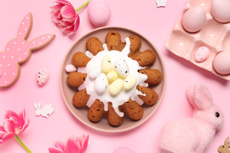 Plate of sweet Easter bread with eggs, rabbits and tulip flowers on pink backgroundの写真素材