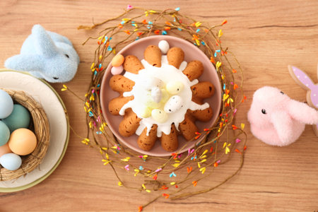 Sweet Easter bread with eggs and toy rabbits on wooden background
