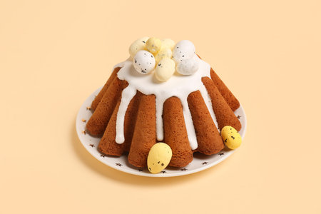 Plate of sweet Easter bread with eggs on yellow background