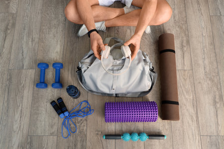 Sporty man with bag and equipment on floor, top viewの写真素材