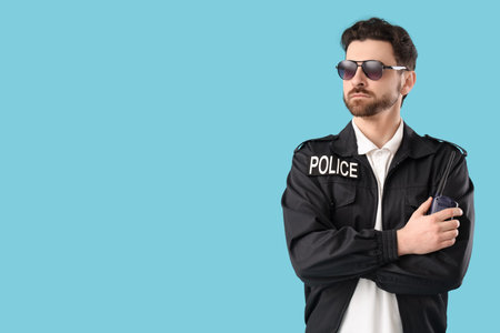 Male police officer with radio transmitter on blue backgroundの写真素材