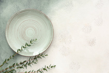 Stylish table setting with plate and plant branches on grunge backgroundの写真素材