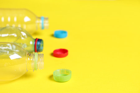 Plastic bottles with caps on yellow backgroundの写真素材