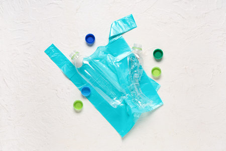 Plastic bag with bottles and caps on light background
