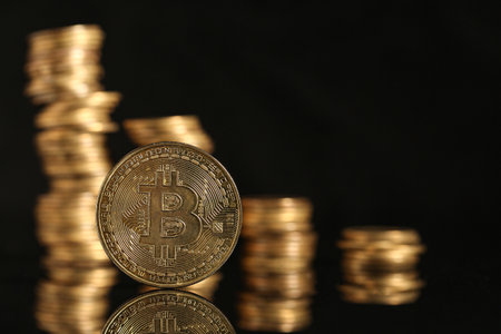 Bitcoin with stacks of coins on black background. Wealth conceptの写真素材