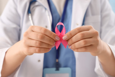 Female doctor with pink ribbon in clinic, closeup. Breast cancer awareness conceptの写真素材