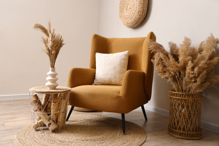 Armchair, coffee table and pampas grass in interior of living roomの写真素材