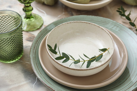 Beautiful table setting with eucalyptus branches on marble background, closeup