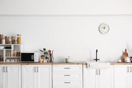 Interior of kitchen with sink, cooking utensils and modern microwave oven on counterの写真素材