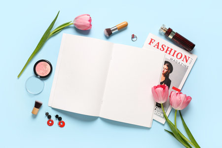 Blank fashion magazine with flowers, cosmetics and jewelery on blue background. Spring season conceptの写真素材