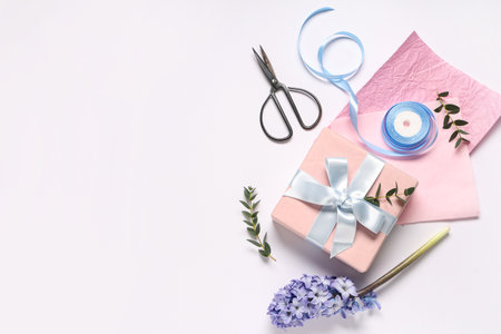 Gift box with flower, wrapping paper and scissors on white background. International Women's Dayの写真素材
