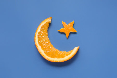 Crescent and star made of orange on color background. Ramadan celebration