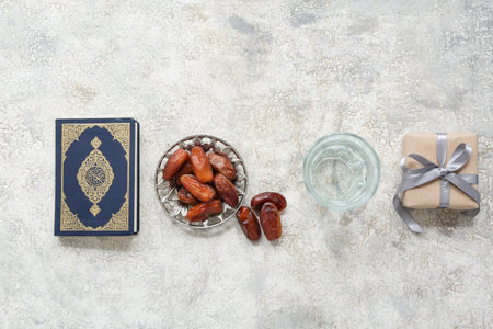Koran, glass of water, dates and gift box on white grunge background. Ramadan celebrationの写真素材
