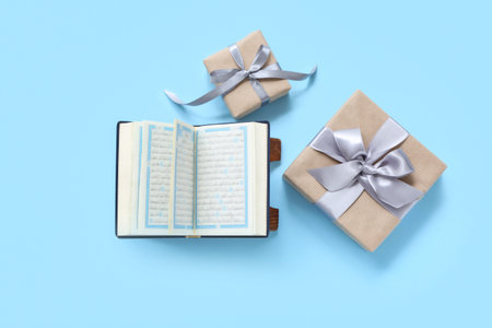 Koran and gift boxes on blue background. Ramadan celebration