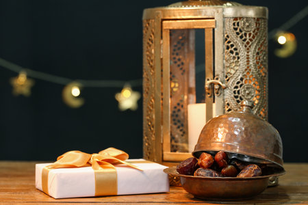 Fanoos, dates and gift box on wooden table against black background. Ramadan celebrationの写真素材