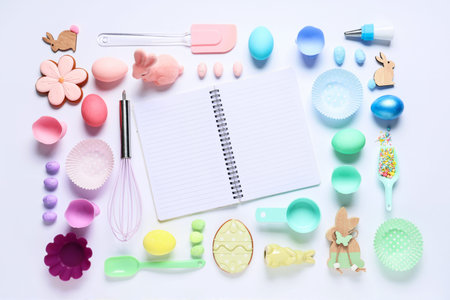 Composition with blank recipe book, baking tools, Easter eggs and cookies on light background