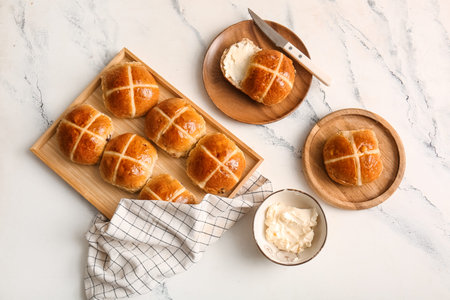 Tray with Easter buns and butter on white grunge background