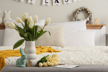 Vase with tulips and Easter rabbit on soft bench in bedroomの写真素材