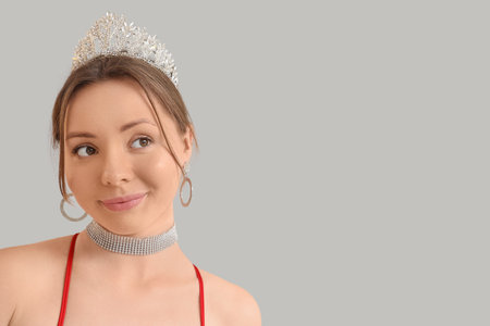 Beautiful young woman in tiara on gray background, closeup. Prom conceptの写真素材