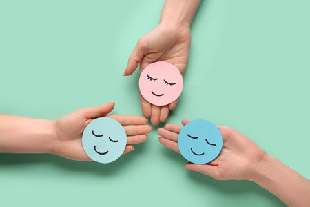 Female hands with paper smiles on green background. World Health Dayの写真素材