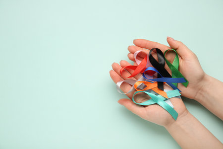 Female hands with different awareness ribbons on green background. World Health Dayの写真素材