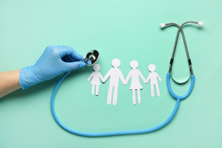 Doctor's hand with stethoscope and children figures on green background. World Health Dayの写真素材