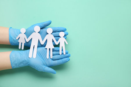 Doctor's hands with children figures on green background. World Health Dayの写真素材