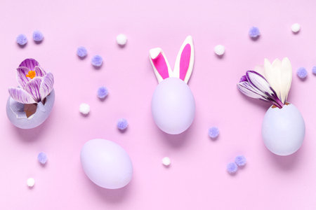 Easter eggs with bunny ears and crocus flowers on pink backgroundの写真素材