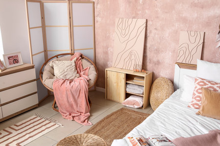 Interior of stylish bedroom with cozy bed, armchair and folding screenの写真素材