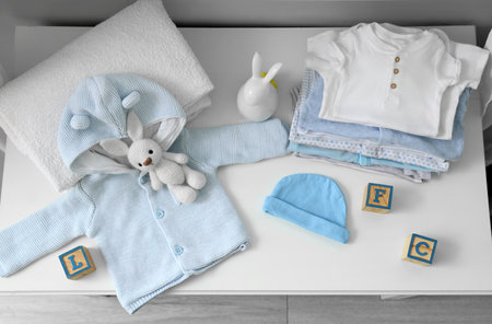 Baby clothes with toys on changing table in room, top viewの写真素材